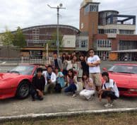 赤いスポーツカーと教習生たちの『集合写真』です。