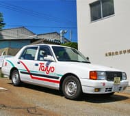 赤とエメラルドグリーンのラインが冴える白い教習車。